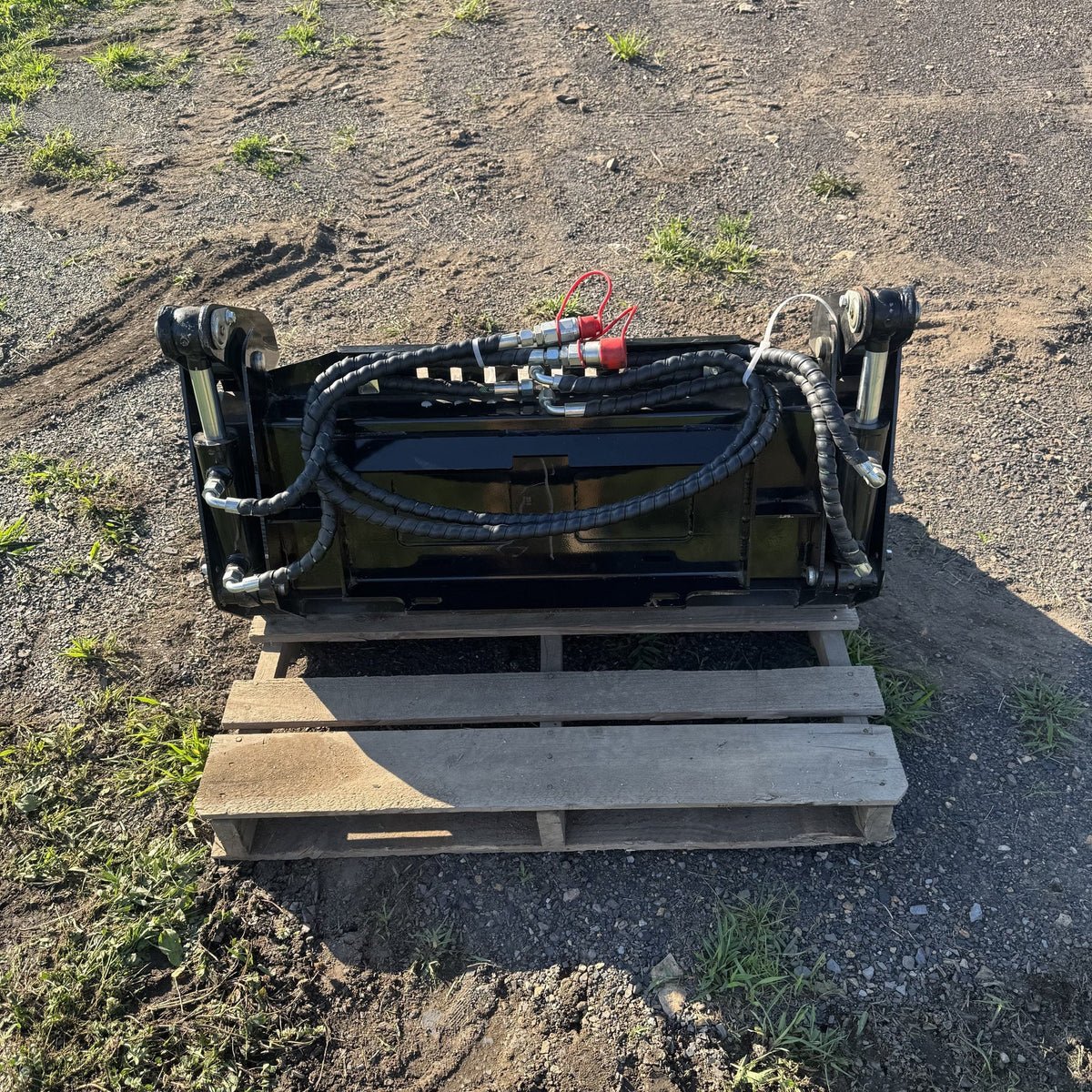 Mount plate side of the 4-in-1 bucket showing hydraulic cylinders and hoses