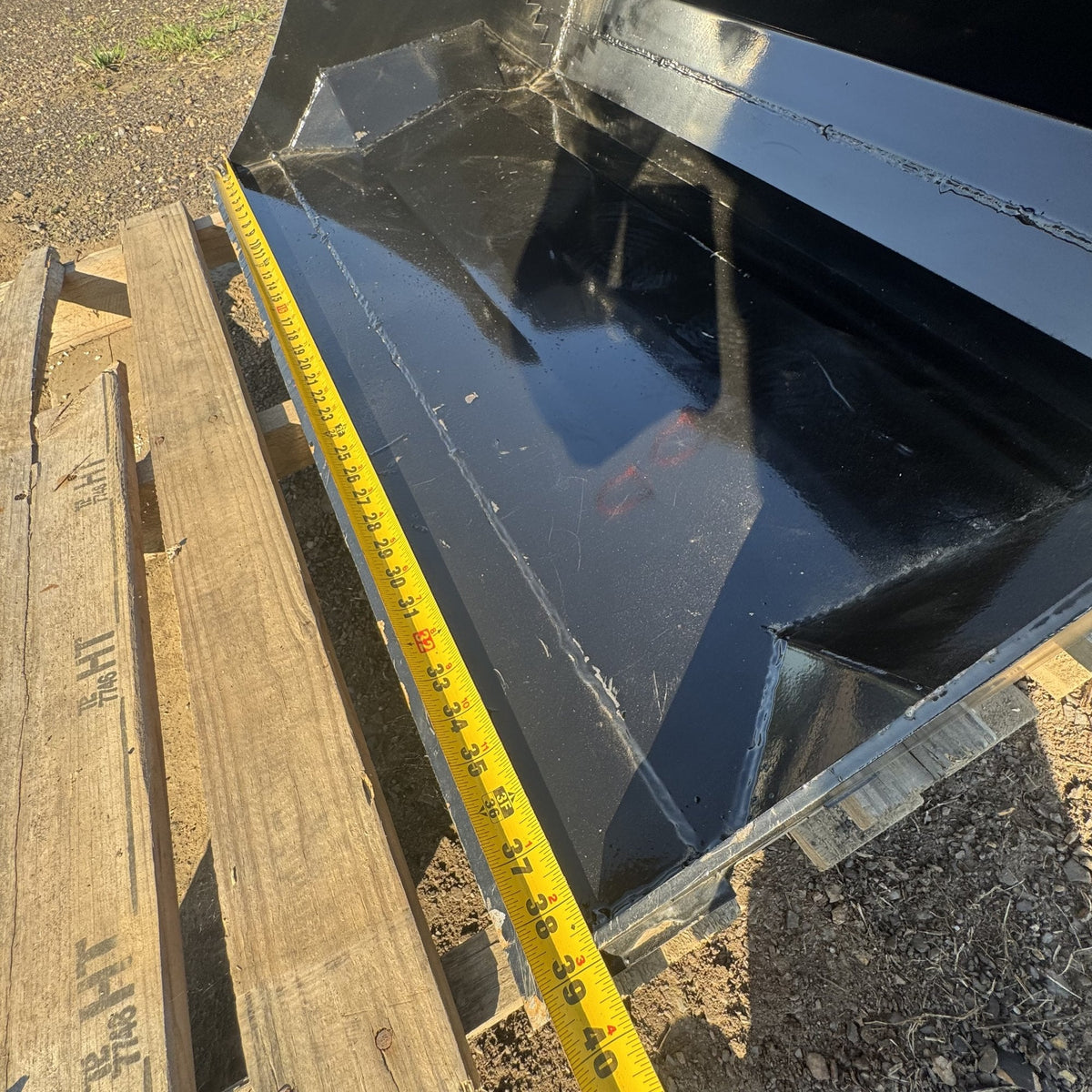 Tape measure across the cutting edge showing bucket width