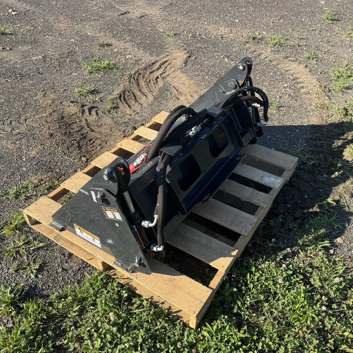 Back of the 4-in-1 bucket showing hydraulic cylinders and hose routing