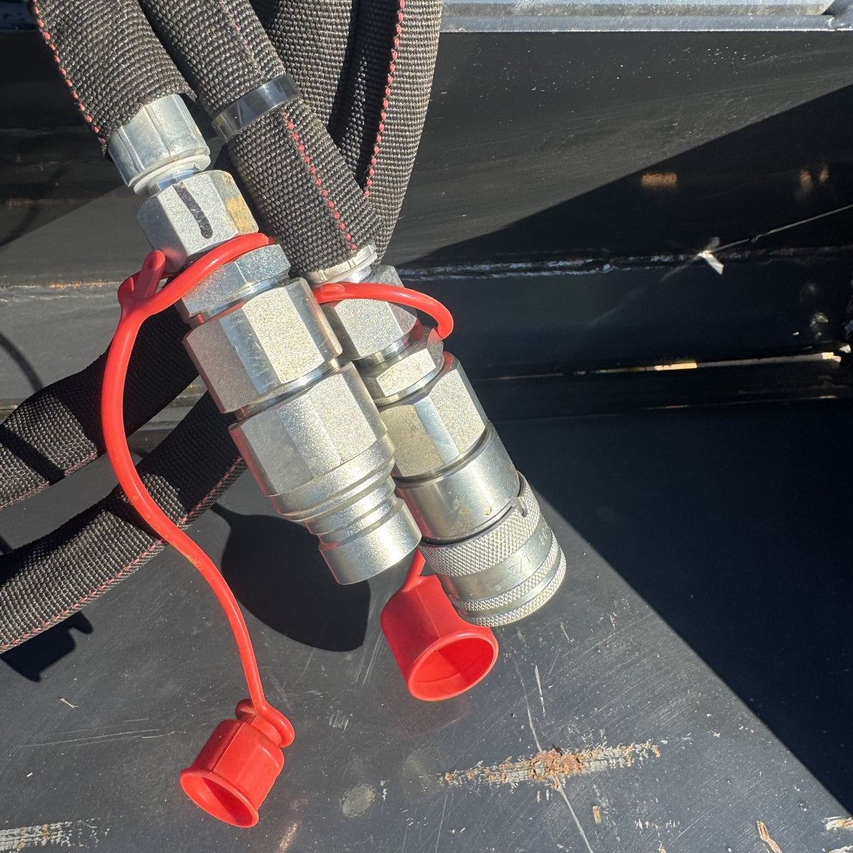 Hydraulic quick couplers with dust caps on the 4-in-1 bucket
