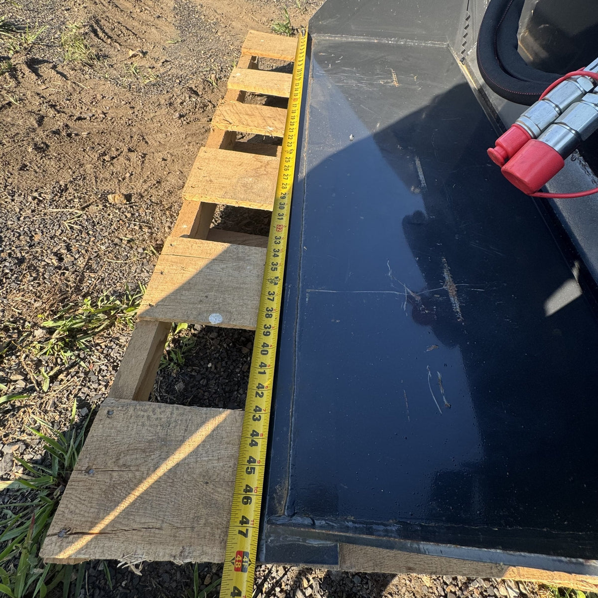 Tape measure across the cutting edge showing bucket width